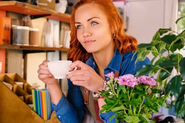 Kızıl saçlı kadın içecekler kahve