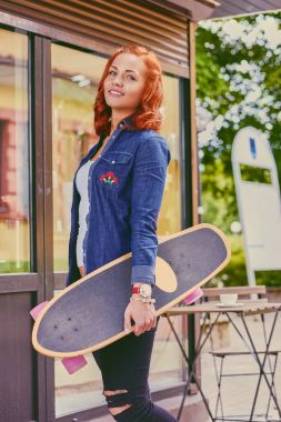 Kızıl saçlı erkek Longboard tutar