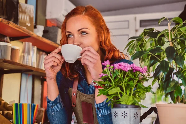 Рыжая женщина пьет кофе. — стоковое фото