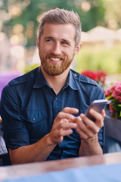 Portrait of positive man using a smartphone — Stock Photo, Image