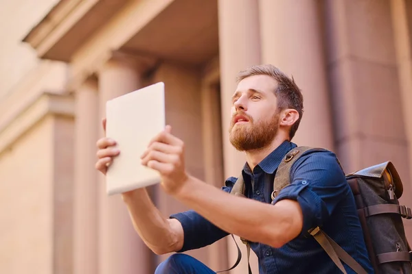 Casual traveler man använder en surfplatta — Stockfoto