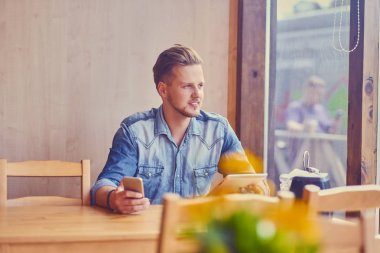 Bir tablet Pc ve smartphone kullanan adam