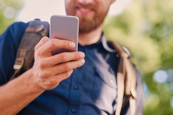 Człowiek posiada srebrny inteligentny telefon — Zdjęcie stockowe