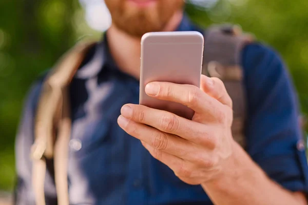 Człowiek posiada srebrny inteligentny telefon — Zdjęcie stockowe