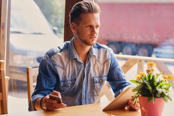 Bir tablet Pc ve smartphone kullanan adam