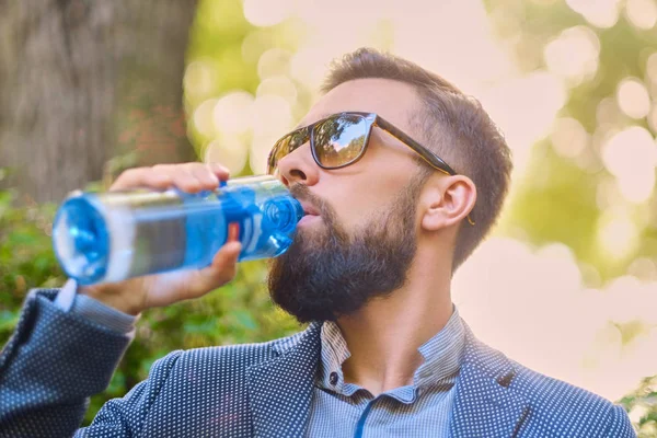 ひげを生やした流行に敏感な男性は水を飲む — ストック写真