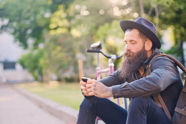 Casual barbudo hipster se sienta en un paso —  Fotos de Stock