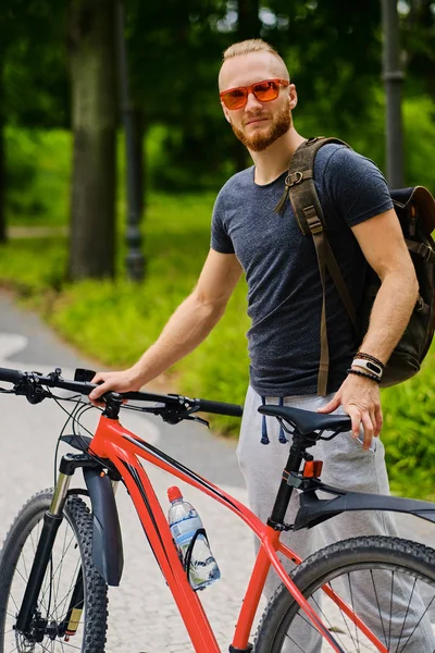 Спортивный самец с красным горным велосипедом — стоковое фото