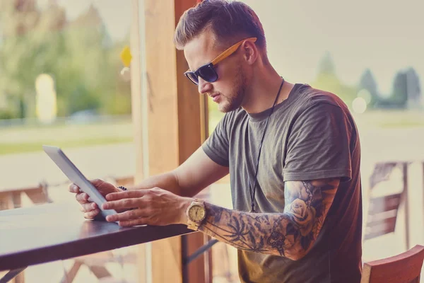 Guy en lunettes de soleil à l'aide d'une tablette PC — Photo