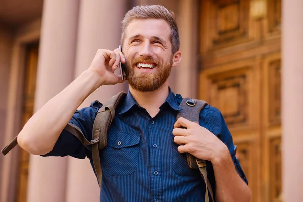 Mannen med ryggsäck som talade genom smartphone — Stockfoto