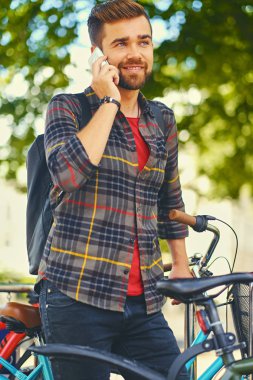 Bisiklet yakınındaki bir akıllı telefon kullanan adam