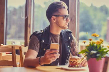 Kafede akıllı telefon kullanan bir adam..