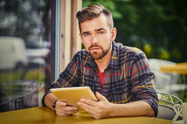 Ο άνθρωπος χρησιμοποιώντας το tablet σε μια καφετέρια. — Φωτογραφία Αρχείου