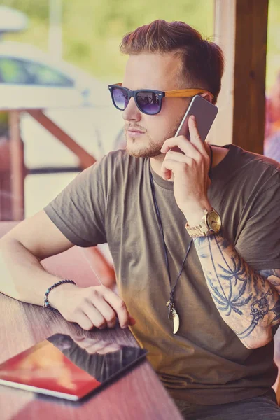 Ο άνθρωπος με το τατουάζ arm συνομιλίες από το smartphone — Φωτογραφία Αρχείου