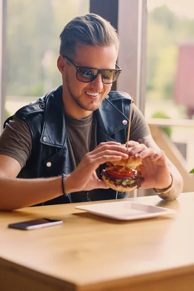 Mannen äter en vegan hamburgare — Stockfoto