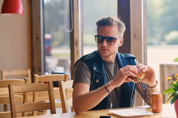 Man eating a vegan burger in cafe