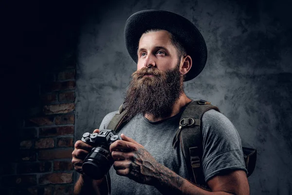 Fotógrafo barbudo sostiene cámara compacta —  Fotos de Stock