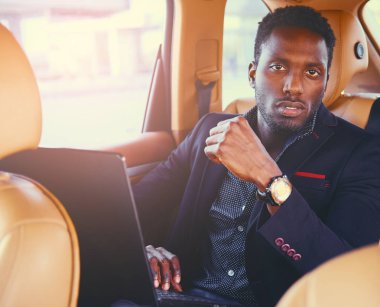 Bir dizüstü bilgisayar kullanarak şık siyah erkek