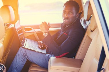 Bir dizüstü bilgisayar kullanarak şık siyah erkek