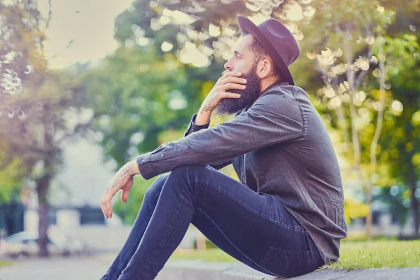 Casual bearded hipster sits on a step — Stock Photo, Image