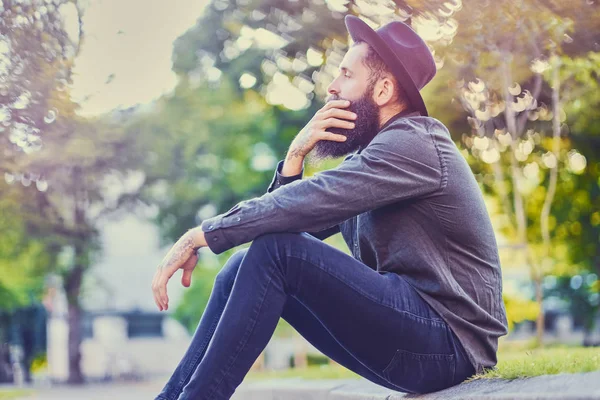 Casual hipster barbudo senta-se em um passo — Fotografia de Stock