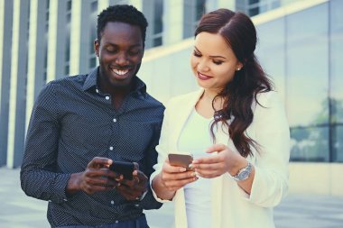Smartphone üzerinde modern bina kullanan kişiler.