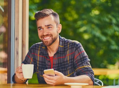 Gülümseyen sakallı erkek içecekler kahve 