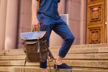 Erkek deri sırt çantası tutar