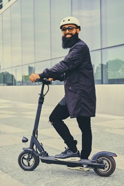 Elektrikli scooter üzerinde şık sakallı adam