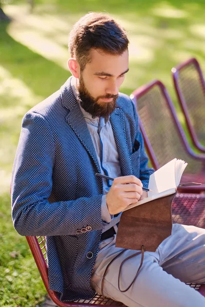 Homem escrevendo uma mensagem para um bloco de notas — Fotografia de Stock