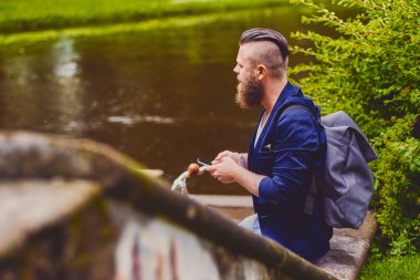Akıllı telefon kullanarak rahat sakallı erkek.