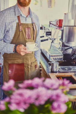Kızıl saçlı sakallı adam dökerek kahve