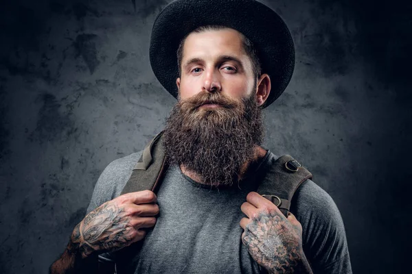Varón tatuado con barba en un sombrero con una mochila — Foto de Stock