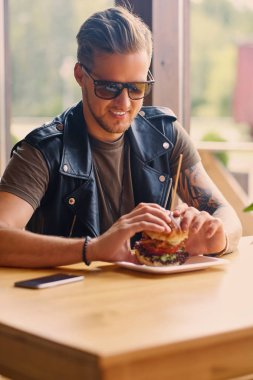 Yenilikçi bir vejetaryen burger yiyen
