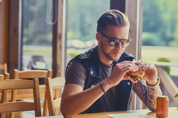 Hipster dressed in leather jacket eating — Stock Photo, Image