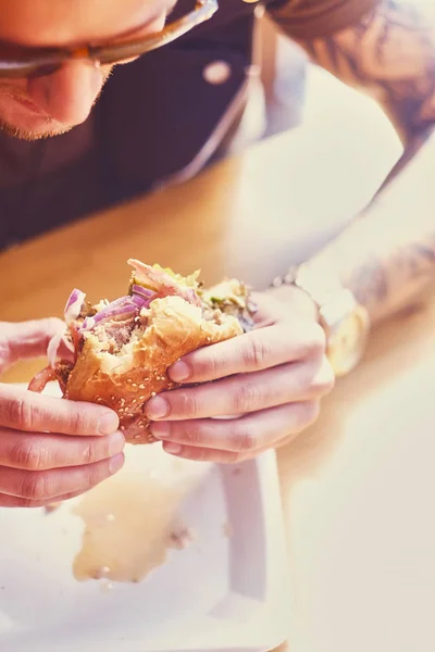 Attraktiva mannen äter en vegan hamburgare — Stockfoto