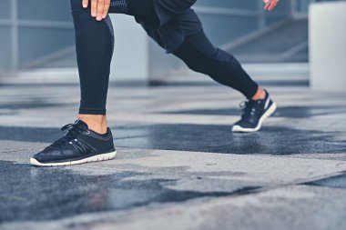 Sportif erkek bacaklarını esnetiyor