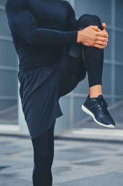 Sportif erkek bacaklarını esnetiyor
