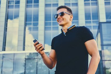 Smartphone kullanarak şık kaslı erkek