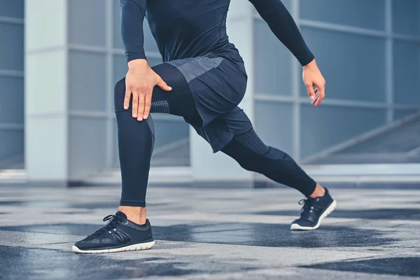 Sporty male is stretching his legs — Stock Photo, Image