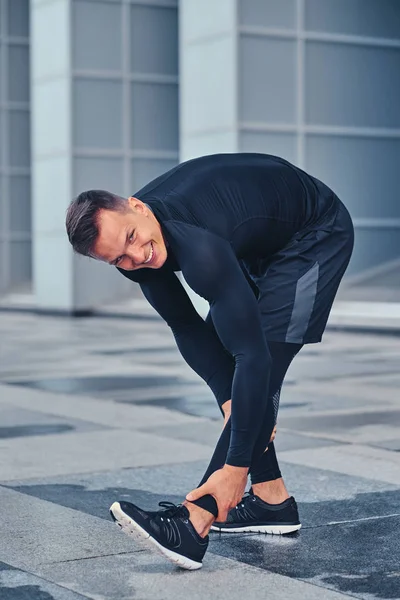 Man stretching outdoors over modern building — Stock Photo, Image