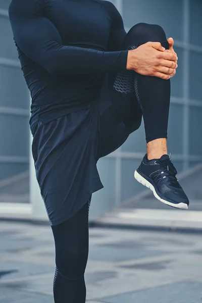 Sportowy mężczyzna jest rozciąganie nogi — Zdjęcie stockowe