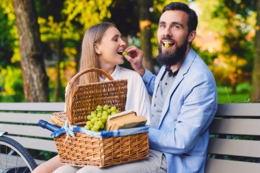 Bir çift bir bankta üzüm yemek