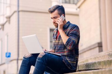 Adam görüşmeler smartphone ve bir dizüstü bilgisayar kullanarak