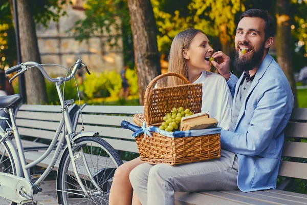 Een paar druif te eten op een bankje — Stockfoto