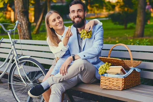 Bir çift bir bankta üzüm yemek