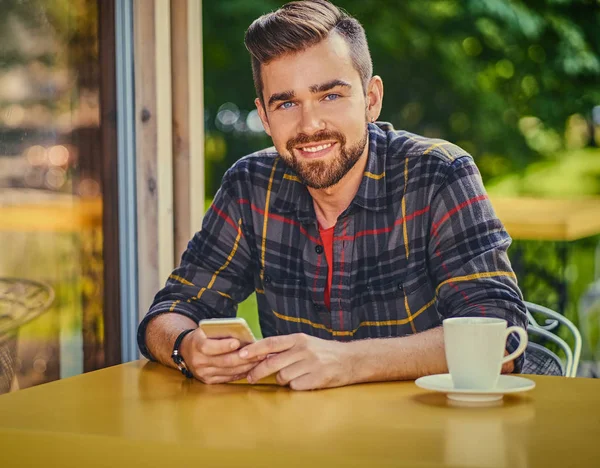 Adam bir kafede kahve içer.