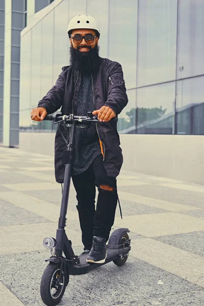 Elektrikli scooter üzerinde poz bir adam.
