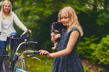 Sarışın kız bir Spitz köpek tutar.