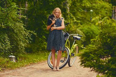 Sarışın kız Spitz köpek tutar